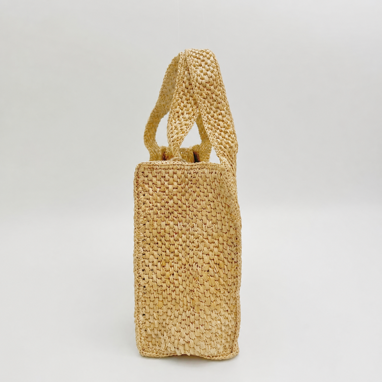Haven Minimalist Woven Tote — side view of Tiger Canada handwoven raffia bag